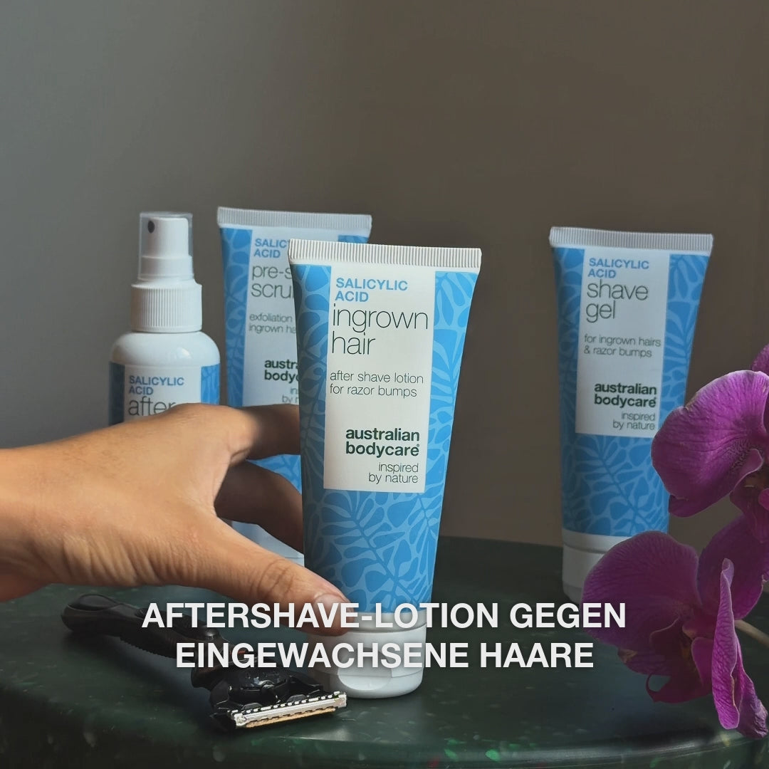 Video: After Shave Spray, Pre-shave Scrub, Ingrown Hair Lotion und Shave Gel stehen auf einem Tisch neben einem Rasierer und einer Orchidee, mit dem Text „Aftershave-Lotion gegen eingewachsene Haare“. Salicylsäure Aftershave Lotion von Australian Bodycare.