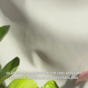 Nahaufnahme einer Hand, die einige feine Tropfen des durchsichtigen, leichten Peeling-Serums auf die Fingerspitzen gibt und es sanft in die gereinigte Gesichtshaut einarbeitet — die seidige, flüssige Textur löst sichtbare abgestorbene Hautzellen, verfeinert die Hautstruktur und steigert die Ausstrahlung mit natürlichen AHAs (Lime Pearl), Niacinamid und Teebaumöl 