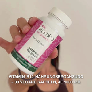 Nahaufnahme einer Hand mit der Vitamin B12 Nahrungsergänzung, die den Deckel öffnet und glatte, weiße Kapseln ausgießt – Darstellung des Produkts zur täglichen Einnahme zur Unterstützung von Energie, Immunsystem, Nervensystem und zur Verringerung von Müdigkeit.